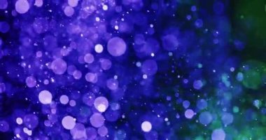 Parlayan mor ve yeşil parçacıklara sahip koyu bir arka plan bir bokeh etkisi yaratır. Bu parlayan parçacıklar uzayda asılı kalmak ya da suda yüzmek gibi bir izlenim verir.