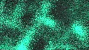Parlak yeşil parçacıklar dinamik bir şekilde koyu bir arkaplana doğru akarlar. Parçacıklar, bazı bölgelerde kümelenmiş ve diğerlerine dağılmış bir sıvı hareketi ve derinlik hissi yaratıyor.,