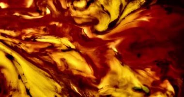 Kırmızı ve sarı sıvı boyanın dinamik hareketi alevlerin ateşli dansını andırıyor.