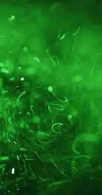 Yeşil atomlar dinamik bir şekilde karanlık bir arkaplanda dönerek bilimsel görselleştirmenin güzelliğini gösterirler.