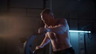 Saldırı bisikletiyle güçlü bir şekilde pedal çeviren bir adam kardiyo çalışmasına odaklanmış.