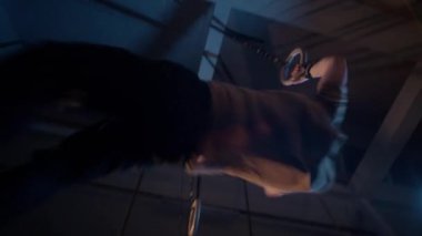 Düşük açılı bir bakış açısı bir Crossfitter 'ın güçlü ve hassas bir şekilde halka kaslarını çalıştırmasını yakalar, atletizmini ve vücut çalışmasının yoğunluğunu vurgular.