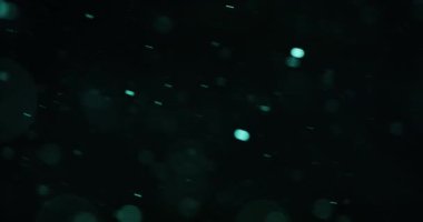 Büyüleyici Cyan bokeh parçacıkları sağa doğru akar, dinamik ve dinamik bir görsel etki yaratır