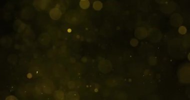 Parlak sarı parçacıklar yavaşça dağılır ve karanlığa karışıp büyüleyici bir ışık ve gölge kontrastı yaratır.