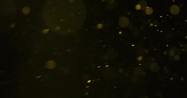 Les particules circulaires jaunes se déplacent rapidement dans toutes les directions sur fond sombre