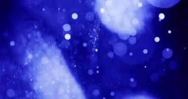 Beyaz bokeh noktaları mavi bir arkaplanda rüya gibi bir etki yaratıyor