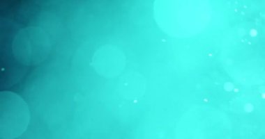 Cyan parçacıklarının büyüleyici bir hareketi zarif bir şekilde yüzüyor ve karanlık bir arkaplanda dönüyor büyüleyici ve dinamik bir görsel efekt yaratıyor.