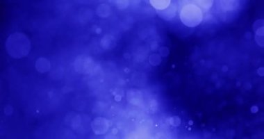 Bokeh ve ışıldayan parçacıklar, sakin mavi bir arkaplanda yavaşça süzülüyorlar.