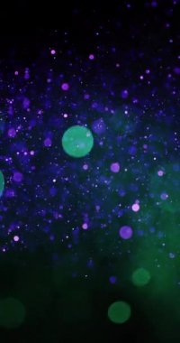 Mor ve yeşil parçacıklar döner ve hareket eder, büyüleyici bir görsel ekran oluşturur