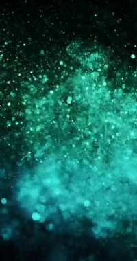 Cyan ve yeşil parçacıklar zarif bir şekilde sola dönerek büyüleyici bir renk ve hareket dansı yaratıyor.