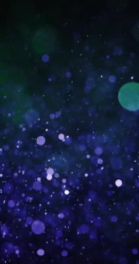 Yumuşak bokeh efektleri eşliğinde mavi ve yeşil parçacıkların aşağı doğru hareketi