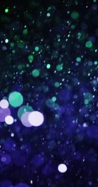 Büyüleyici mavi ve yeşil parçacıkların girdabı büyüleyici bokeh daireleri ile dinamik ve huzurlu bir görsel zemin oluşturur.