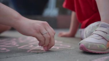 Bir kadın çocukken tebeşirle pembe kalpler çizer her kalbin kaldırımda nereye gitmesi gerektiğini hevesle işaret eder.