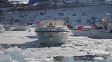 Buzla kaplı sularla kaplı donmuş kış manzarasının zeminine karşı bir liman dolusu tekne.