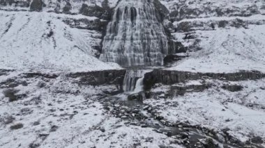 İnsansız hava aracı görüntüleri, karlı bir araziden yükselen görkemli şelaleyi yakalar.