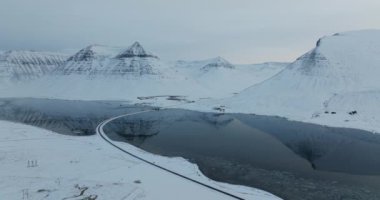 Karla kaplı dağların nefes kesici panoramik görüntüsü sakin bir göle yansıyarak doğanın huzur dolu güzelliğini ve ihtişamını gözler önüne seriyor.