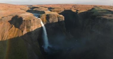Bir hava manzarası, İzlanda 'daki Haifoss ve Granni şelalelerinin ihtişamını, göz kamaştırıcı çağlayanları ve etrafındaki engebeli manzaraları yansıtıyor.
