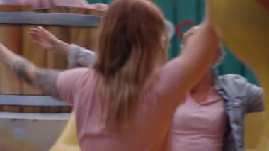 İki kadın panayırda ördek şeklinde bir atlıkarıncaya biniyor. Atlıkarınca dönerken, kadınlar kollarını kaldırıp heyecanla gülüyorlar.