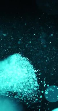 Bir turkuaz parçacık bulutu, karanlık bir arkaplana karşı havada asılı duruyor. Parçacıklar yoğun bir şekilde merkezde toplanır ve kenarlara doğru dağılır.