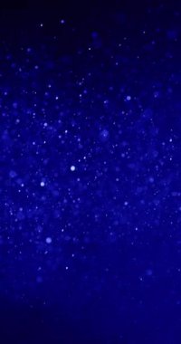 Kar tanelerine ya da toz tanelerine benzeyen parçacıklardan oluşan bir şelale koyu mavi bir arkaplandan iner. Parçacıklar boyut ve parlaklık olarak farklılık gösterir