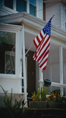 Evin ön verandasında gururla bir Amerikan bayrağı sergileniyor. Ev halkının vatanseverlik duygusu yaratıyor.