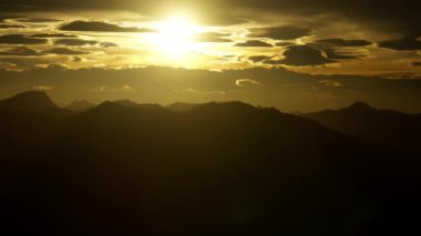 Bir zaman dilimi, güneş batarken gökyüzünü yavaş yavaş kararıyor görkemli dağların üzerinden