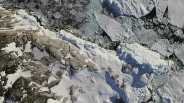 Grönland 'da kar ve buz oluşumlarıyla çevrili engin buzlu arazide yürüyen bir maceracının kuş bakışı görüntüsü.
