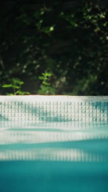 Havuz kenarındaki kiremitlerin ve berrak suyun büyüleyici görüntüsü yemyeşil bir zemin üzerine kurulmuş.