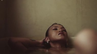 Küvette banyo yapan bir kadın, zihnini ve bedenini rahatlatmasını sağlar.