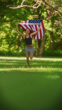 Genç bir kız sevinçle koşuyor, Amerikan bayrağını iki elinde tutuyor ve hareketleriyle birlikte renkleri de canlı akıyor.