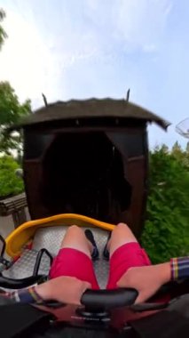 Sarı lunapark treninde hızlı bir sürüşün ön koltuk POV 'si, birinci şahıs perspektifinden her kıvrım ve dönüşü yakalıyor.