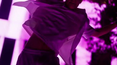 Hollandalı bir genç adamın hip hop dansı yaparken sahne arkası olarak pembe bir renkle yıkanmış bir binayla dinamik hareketlerini ve hareketli ışıklandırmasını vurguluyor.