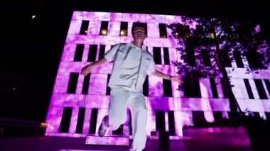 Filmby Aarhus binasının canlı pembe ışıkla yıkanması ve dansçının dinamik hareketlerini ön plana çıkaran çarpıcı bir kontrastın ortaya çıkmasıyla bir şehir hip hop performansı ortaya çıkıyor.