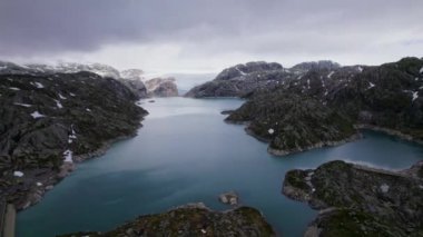 İniş sahnesi, Norveç 'te yükselen kayalık dağlarla çevrili geniş bir fiyordu gözler önüne seriyor. Bu çarpıcı doğal manzaranın engin mavi sularını ve dramatik zirvelerini vurguluyor.