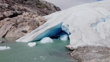 Nigardsbreen Buzulu 'ndan akan erimiş su akıntısı engebeli, kayalık arazide doğal manzaranın el değmemiş ve el değmemiş güzelliğini vurguluyor.