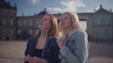 Amalienborg 'un muhteşem manzarası ve tarihi cazibesine hayran iki kadın bir arada duruyor.