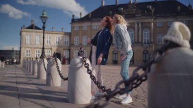 Amalienborg Sarayı 'nın önünde duran iki turist, güzel bir günde manzaranın tadını çıkarıyorlar.