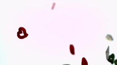 Kalp kırıntıları zarif bir şekilde beyaz bir arkaplanda süzülür. Tuhaf ve büyüleyici bir görsel etki yaratır.