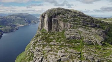 İnsansız hava aracı, gür, kayalık dağlar tarafından çerçevelenmiş Norveç kıyılarının çarpıcı sularını yakalıyor.