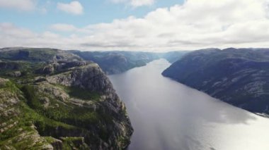 Bulutlu bir günde Norveç 'in görkemli dağları arasında akan bir nehri yakalayan bir dron görüntüsü.