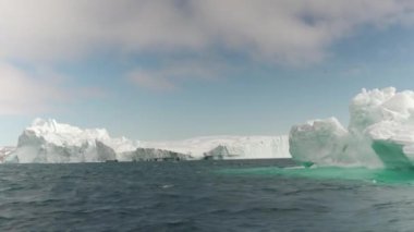 Okyanusun engin genişliğinde yüzen devasa buzdağları.