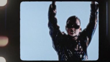An artist in stylish sunglasses confidently displays a decorative metal sign inscribed with Shit Happens in a contemporary studio setting