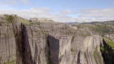 İnsansız hava aracının yakaladığı çarpıcı bir yay görüntüsü Minber Rock 'ta turistleri gösteriyor. Kamera zarafetle uçurumun etrafını tarıyor ve Lysefjorden' ın nefes kesici manzarasını gözler önüne seriyor.