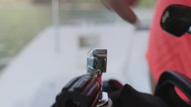 Yakından çekilen bir el, parlak bir krom konnektörü, siyah kauçuk ve plastik bileşenlere karşı ışığı yansıtan bir tüp vanasına dikkatlice ayarlar.