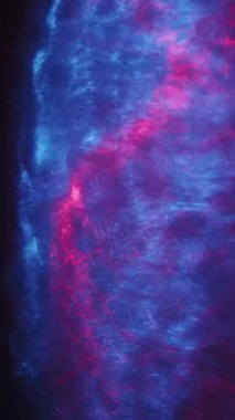 Kırmızı ve mavi ışık dalgaları düzgün süzülerek karanlık bir arkaplan karşısında büyüleyici dairesel desenler oluşturarak dinamik ve hipnotik bir görsel etki yaratır.