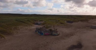 Yukarıdan, canlı graffiti Vesterhavet kıyısında kayalara yayılıyor, deniz ve yemyeşil tepeler arkasında durmadan uzanıyor.