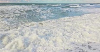 Vesterhavet 'in engin denizinin köpüklü dalgaları rahatlatıcı bir ritimle hareket eder, her dalga nazik bir zarafetle akar, pürüzsüz kumların üzerine ışıldayan bir su tabakası yayar.