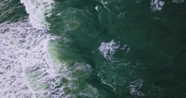 Göz kamaştırıcı bir hava manzarası Vesterhavet 'in çarpıcı dalgalarını yakalar. Bu dalgalar, tepelerinde oluşan köpüklü köpükle çelişen geniş dalgalar gibi görünür.