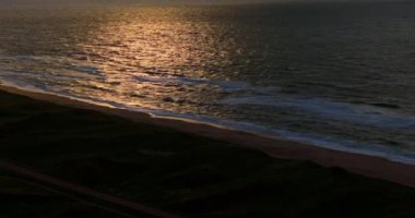 İnsansız hava aracı, Vesterhavet Sahili 'nin sakin sularında sakin günbatımı yansımalarını sergiliyor.