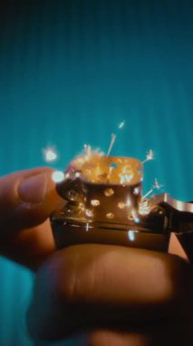 Yakın çekim, yavaş çekim yoğun kıvılcımlar ve alev püsküren bir metal çakmak, dramatik ateşleme sürecini canlı detaylarla vurguluyor.